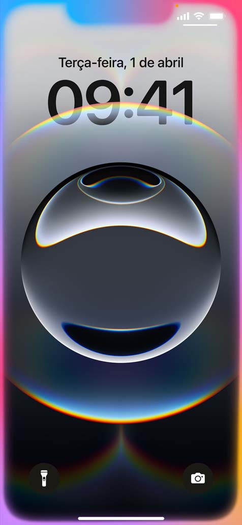 Mão segurando o iPhone 16e com um brilho colorido nas bordas ao redor da Tela Bloqueada.