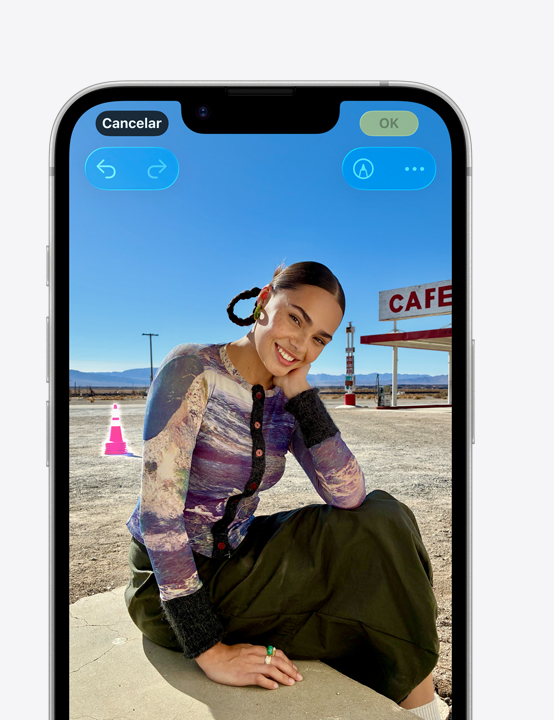 A tela do iPhone, com a foto de uma pessoa sorrindo na praia, mostra como remover um cone ao fundo com a ferramenta Limpar