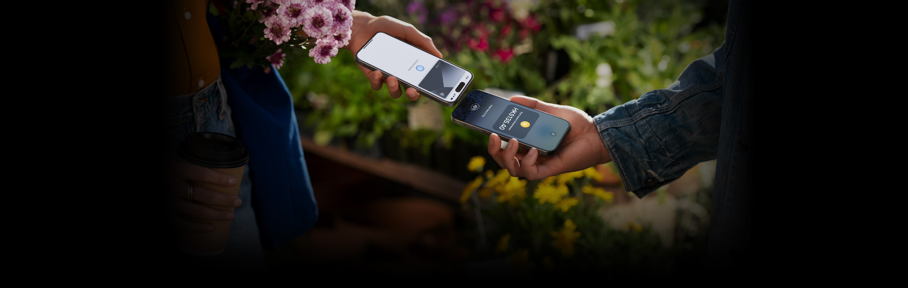 圖片顯示兩個人手持 iPhone 完成交易。