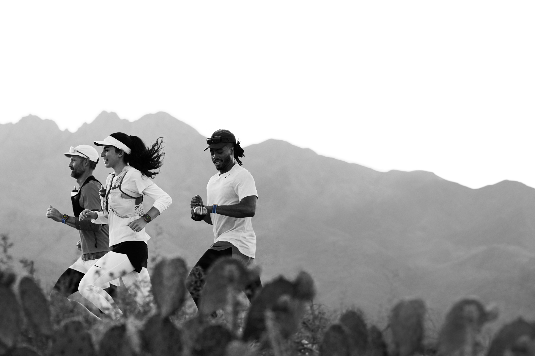 Varias personas corren por una pista en el desierto y registran su entrenamiento en el Apple Watch Ultra 3