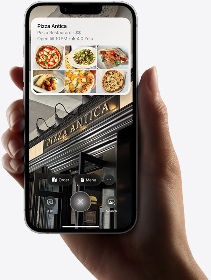 Ranka, laikanti „iPhone 16e“, kuriame rodomi „Visual Intelligence“ rezultatai.