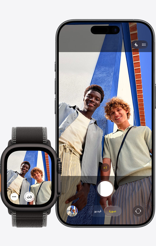 جهاز iPhone 17، الجزء الأمامي الخارجي، الكاميرا قيد الاستخدام لالتقاط صورة سيلفي جماعية، بجانب ساعة Apple Watch Ultra 3 مع تطبيق ريموت الكاميرا مفتوح