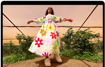 Liquid Retina ekranın renk aralığını ve çözünürlüğünü göstermek için MacBook Air ekranında renkli kıyafetli birinin fotoğrafı gösteriliyor