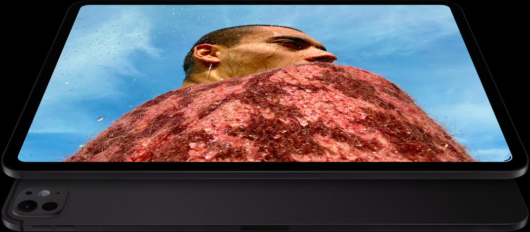 iPad Pro, предна външна част, хоризонтална ориентация, цвят астро черно, заоблени ъгли, черна рамка на дисплея, дисплей, показващ снимка на мъж в червен пуловер под синьо небе, отдолу, друг iPad Pro, задна външна част, хоризонтална ориентация, цвят астро черно, про система камери, бутон за увеличаване на звука, бутон за намаляване на звука