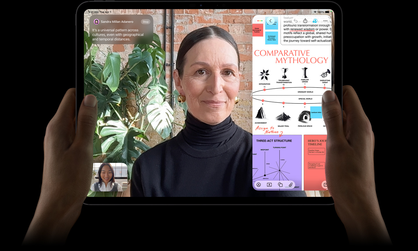 iPad Pro, предна външна страна, цвят астро черно, лява и дясна ръка в хоризонтална ориентация, заоблени ъгли, черна рамка на дисплея, дисплей, показващ разговор във FaceTime, който се превежда на живо, и образователно приложение, показващо презентация на „Сравнителна митология“ с текст, диаграми и ръкописни бележки