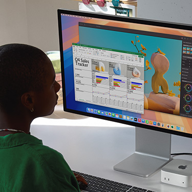 Người phụ nữ ngồi ở bàn làm việc và thao tác trong bảng tính Excel trên máy Mac. Bảng tính Excel là bảng theo dõi doanh số bán hàng Quý 4. Phía sau cửa sổ bảng tính Excel là cửa sổ Pixelmator Pro.